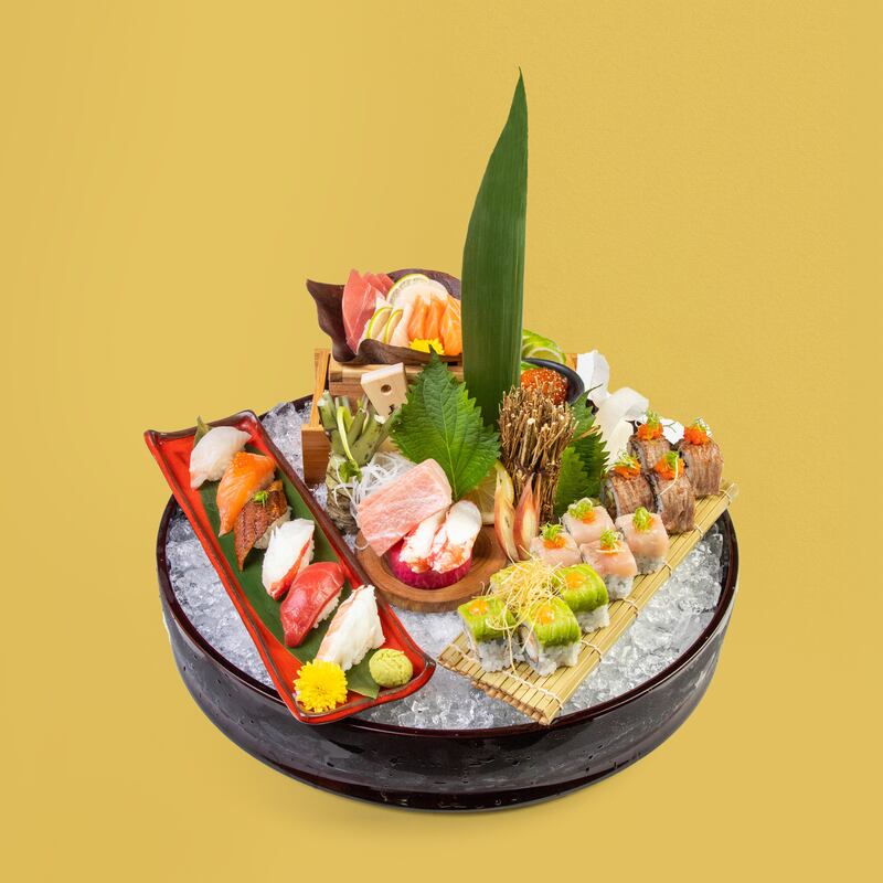 A platter of finely sliced sushi, rolls and sashimi.