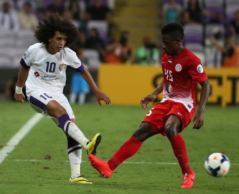 Al Ain's Omar Abdulrahman passes the ball under pressure from Al Jazira's Ahmed Al Ghilani during the second leg of their AFC Champions League tie on Tuesday. Karim Sahib / AFP / May 13, 2014