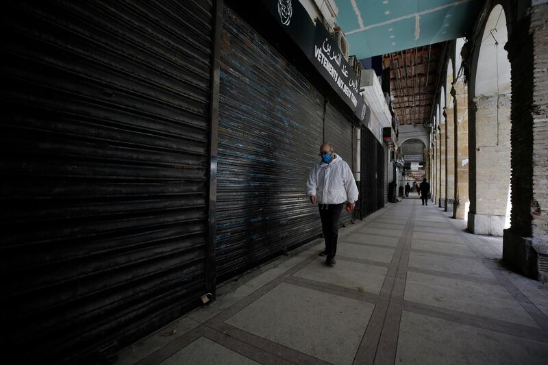 A man walks by closed shops in Algiers. AP Photo
