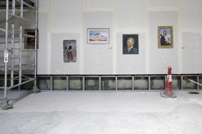 Copies of famous old masters have been printed out and stuck to one of the Louvre Abu Dhabi's gallery walls during its internal construction. Christopher Pike / The National