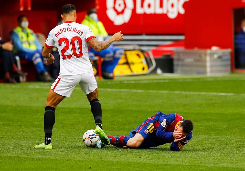 Barcelona's Lionel Messi holds his face after a challenge by Diego Carlos of Sevilla. Reuters