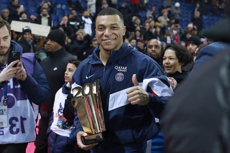 Kylian Mbappe celebrates with a trophy after scoring his record 201st goal for PSG. EPA