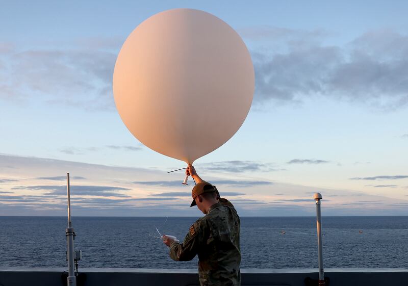 A member of the US Air Force uses a weather balloon aboard the USS Portland, sent to retrieve the Orion capsule after it splashed down in the Pacific off Mexico. AP
