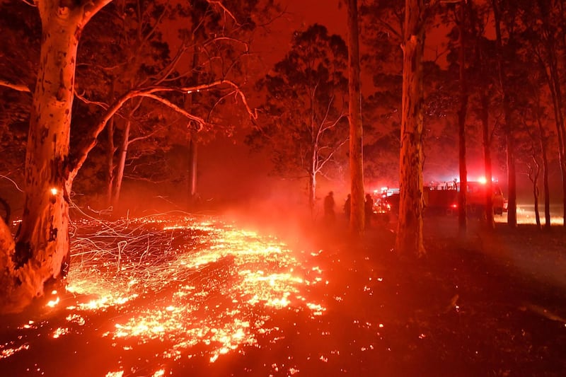Burning embers cover the ground as firefighters battle against bushfires. AFP
