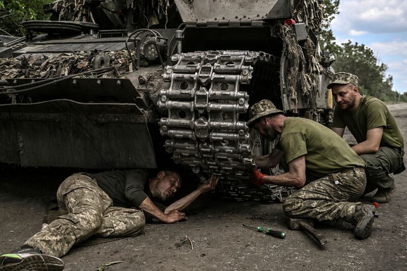 Ukrainian troops repair a tank in the Donbas region. AFP