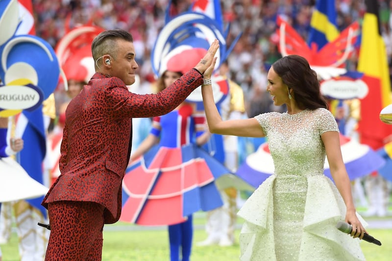TOPSHOT - English musician Robbie Williams (L) and Russian soprano Aida Garifullina perform during the Russia World Cup opening ceremony before the tournament's first match between Russia and Saudi Arabia on June 14, 2018 at Moscow’s Luzhniki Stadium. / AFP / Patrik STOLLARZ
