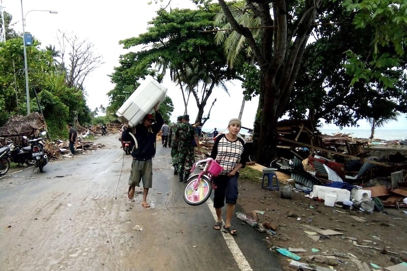 Residents evacuate from damaged homes on Carita beach. AFP