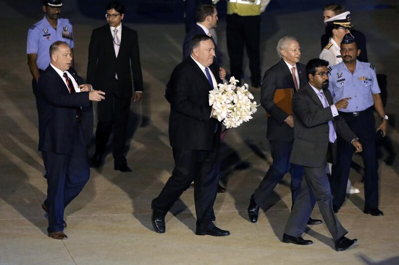 Mike Pompeo receives a bouquet of flowers as he arrives at Air Force Station Palam in Delhi. Bloomberg
