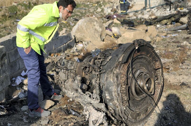 TEHRAN, IRAN - JANUARY 08: An official inspects a piece of the plane at site after a Boeing 737 plane belonging to Ukrainian International Airlines crashed near Imam Khomeini Airport in Iran just after takeoff with 180 passengers on board in Tehran, Iran on January 08, 2020. All 167 passengers and nine crew members on an Ukrainian 737 plane that crashed near Iran's capital Tehran early Wednesday have died, according to a state official. (Photo by Fatemeh Bahrami/Anadolu Agency via Getty Images)