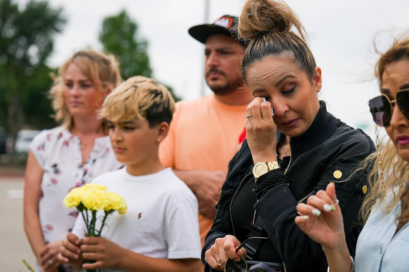 Sara Tabatabaie wipes away a tear at a memorial outside  the mall.  AP