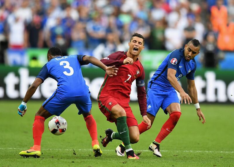 PARIS, FRANCE - JULY 10:  Cristiano Ronaldo (C) of Portugal is challenged by Patrice Evra (L) and Dimitri Payet (R) of France during the UEFA EURO 2016 Final match between Portugal and France at Stade de France on July 10, 2016 in Paris, France.  (Photo by Laurence Griffiths/Getty Images)