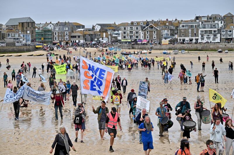 ST IVES, UNITED KINGDOM â€“ JUNE 11:  Extinction Rebellion (XR) activists take part in the "Sound The Alarm" march during the G7 summit in Cornwall on June 11, 2021 in St Ives, Cornwall, England. Environmental Protest Groups gather in Cornwall as the UK Prime Minister, Boris Johnson, hosts leaders from the USA, Japan, Germany, France, Italy and Canada at the G7 Summit in Carbis Bay. This year the UK has invited Australia, India, South Africa and South Korea to attend the Leaders' Summit as guest countries as well as the EU. Protest groups hope to highlight their various causes to the G7 leaders and a global audience as the eyes of the world focus on Cornwall during the summit. (Phot by Jeff J Mitchell/Getty Images)