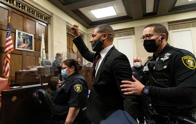 Smollett raises his fist in the air as he is led out of the courtroom after being sentenced to jail time.