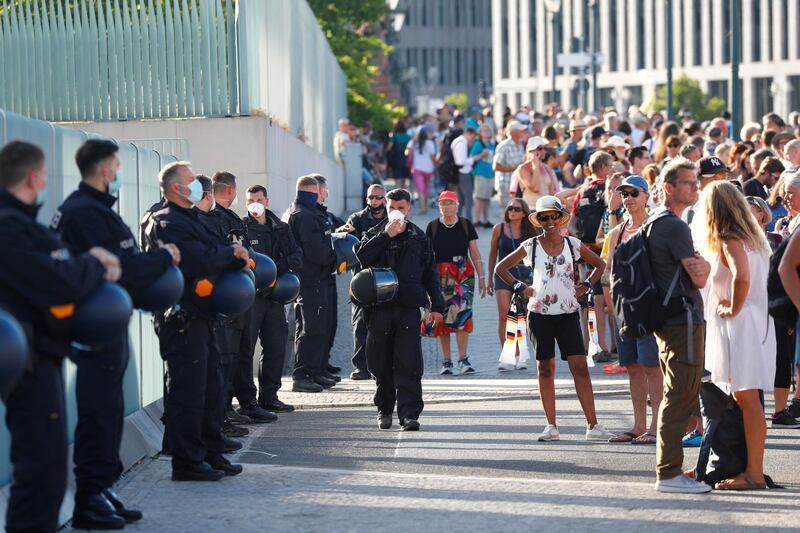 Police officers wear protective face masks as people gather outside Angela Merkel's Chancellery to protest against the government's restrictions amid the coronavirus disease (COVID-19) outbreak, in Berlin, Germany. REUTERS