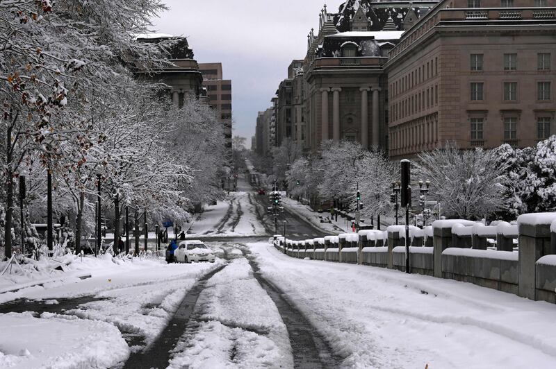 A nearly empty street is covered in snow after the winter storm further snarled US transport and shuttered the federal government and schools. AFP