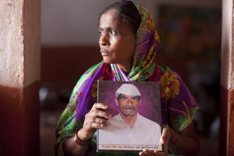Kamalbai with a picture of her farmer husband Mahakant Mali, 55, who committed suicide by hanging himself from a dried Mango tree after failed crops plunged him into debt. (Subhash Sharma for The National) 