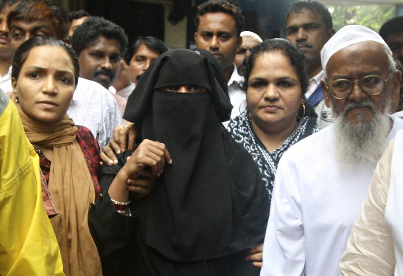 Rohida Faiz Usmani (C, in black), widow of Faiz Usmani, who died during police custody following recent bomb blasts, is seen outside a hospital with a crowd following news of her husband's death in Mumbai on July 17, 2011. An Indian man died of a brain haemorrhage July 17 after being questioned by Mumbai police over the recent bomb blasts, officials said, denying family accusations that he had been mistreated. AFP PHOTO/STR
 *** Local Caption ***  437739-01-08.jpg
