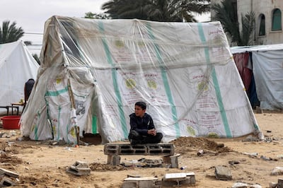 A Palestinian boy sits near a tent for displaced people in Rafah, in the southern Gaza Strip. AFP