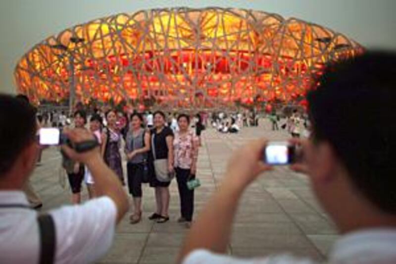 Tourists snap photographs outside Beijing's National Stadium, popularly known as the Bird's Nest.