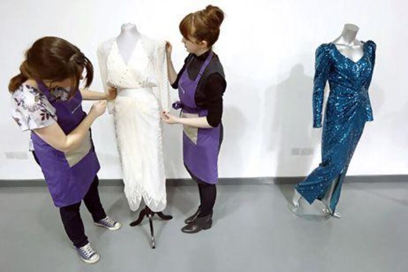 Auction-house employees prepare gowns worn by the late Princess Diana for sale last week in London. Suzanne Plunkett / Reuters