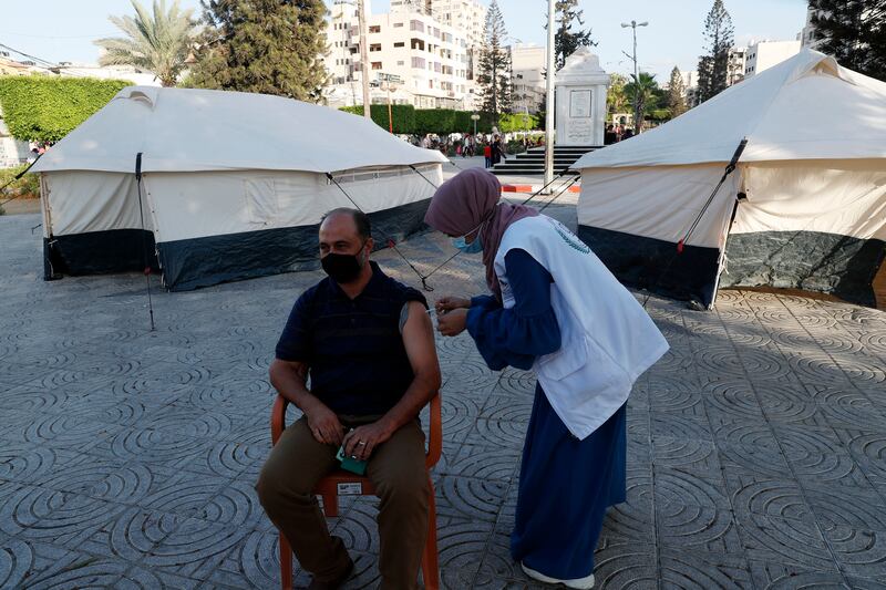 A nurse gives a shot of the Pfizer Covid-19 vaccine to a resident at temporary clinic tents in Gaza City. AP