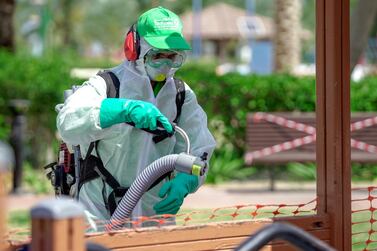 A Tadweer worker sprays a children's play area with disinfectant in Abu Dhabi. Victor Besa / The National 