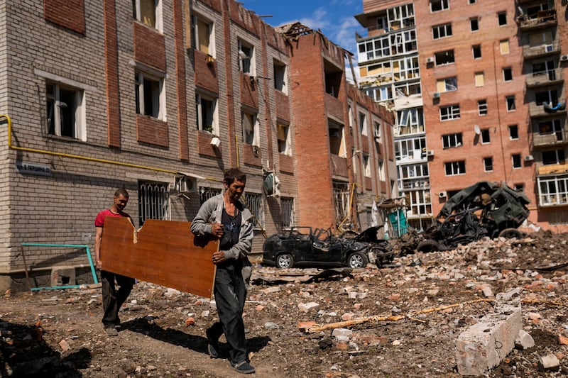 Men with salvageable material from damaged buildings after Russian bombing in Bakhmut, eastern Ukraine. AP
