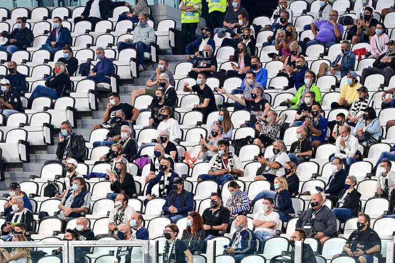 Socially distanced spectators watch the game. AFP