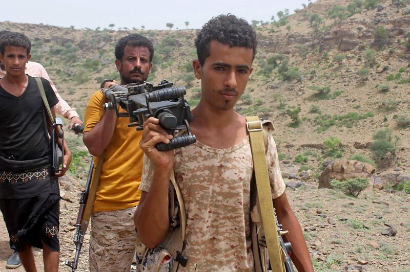 Yemeni pro-government fighters carry a heavy machine gun.