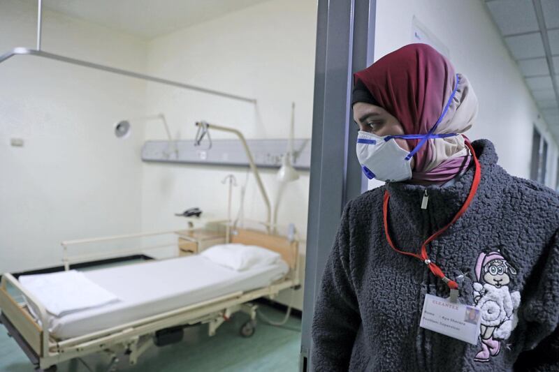 TOPSHOT - A Lebanese employee wearing a protective mask looks at a bed in a ward where the first case of  coronavirus in the country is being treated, at the Rafik Hariri University Hospital in the southern outskirts of the capital Beirut, on February 22, 2020. Lebanon confirmed on February 21, the first case of the novel coronavirus, found in a 45-year-old Lebanese woman who had travelled from the holy city of Qom in Iran, while two other cases were being investigated. / AFP / ANWAR AMRO
