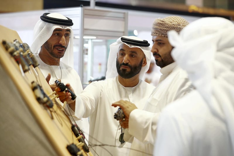 ABU DHABI ,  UNITED ARAB EMIRATES , AUGUST 27 – 2019 :- Visitors looking guns at one of the stand during the ADIHEX 2019 held at ADNEC in Abu Dhabi. ( Pawan Singh / The National ) For News/Online/Instagram/Big Picture. Story by Daniel 