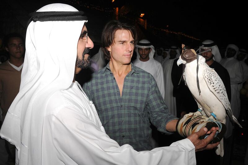 A handout picture released by the government of Dubai shows Dubai ruler Sheikh Mohammed bin Rashed al-Maktoum explaining to Hollywood actor Tom Cruise (R) how to balance a falcon on his arm on November 2, 2010. Cruise is in Dubai shooting "Mission: Impossible - Ghost Protocol". AFP PHOTO/HO == RESTRICTED TO EDITORIAL USE == (Photo by - / GOVERNMENT OFFICE / AFP)