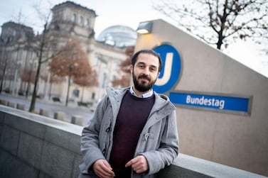 Syrian refugee Tarek Alaows in front of the Reichstag, the seat of the Bundestag, with the adjacent underground station in Berlin also seen in the background, on March 2, 2021. AFP