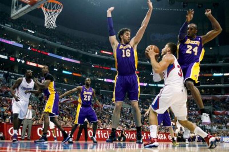 Los Angeles Clippers forward Blake Griffin (2nd R) controls the ball with Los Angeles Lakers forward Pau Gasol (16) of Spain and Lakers guard Kobe Bryant (24) defending during the first half of their NBA basketball game in Los Angeles, California April 7, 2013. Clippers won the game 109- 95 to clinch the Pacific Division title. REUTERS/Alex Gallardo (UNITED STATES - Tags: SPORT BASKETBALL)