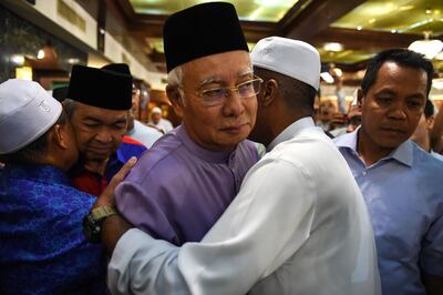 Malaysia's former prime minister Najib Razak (C) and former deputy prime minister Ahmad Zahid Hamidi (2nd L) are greeted by supporters after Friday prayers at the Barisan Nasional party headquarters in Kuala Lumpur on May 18, 2018.  Just last week, 64-year-old Najib was widely expected to lead his powerful Barisan Nasional (National Front) political machine to victory, extending a more than six-decade reign that had made it one of the world's longest-serving governments. But his coalition -- accused of ballot-box stuffing and gerrymandering -- was unexpectedly trounced by a diverse alliance that rallied public support against Najib's suspected corruption and increasingly repressive tactics. / AFP / Mohd RASFAN
