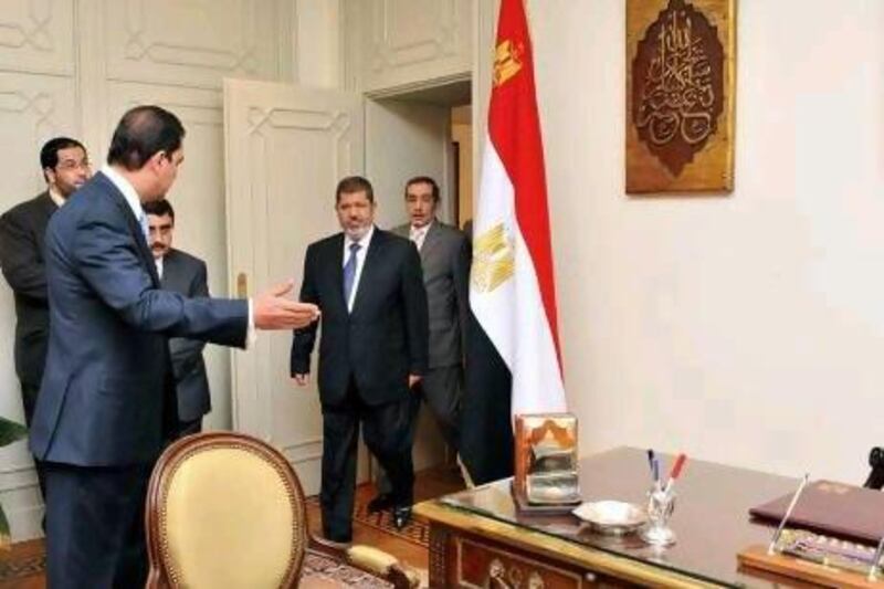 President elect Mohammed Morsi (second from right) arrives in his office in ousted leader Mubarak’s former palace.