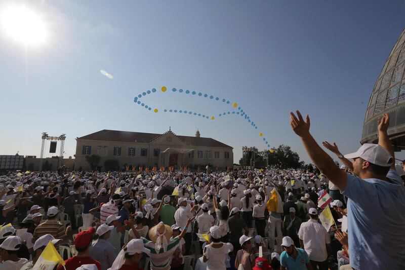 Lebanese Catholic youths cheer Pope Benedict XVI upon his arrival to the Maronite patriarchat in Bkerke on September 15, 2012. Pope Benedict XVI urged Middle Eastern Christians and Muslims to forge a harmonious, pluralistic society in which the dignity of each person is respected and the right to worship in peace is guaranteed. AFP PHOTO / JOSEPH EID (Photo by JOSEPH EID / AFP)