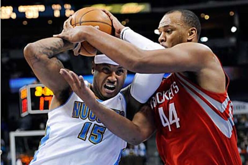 The Nuggets forward Carmelo Anthony, left, is fouled by Rockets center Chuck Hayes during the fourth quarter.