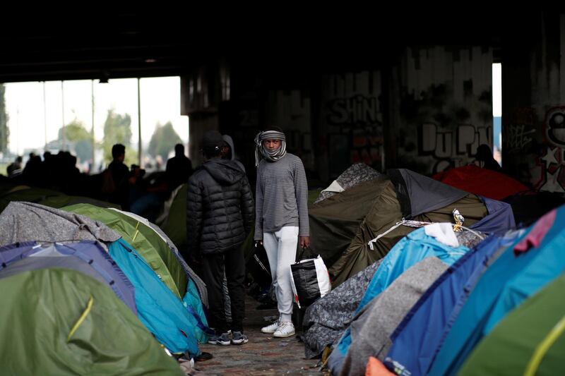 A migrant carries his belongings near tents as French police evacuate hundreds of migrants living in makeshift camps in Paris, France. Benoit Tessier / Reuters