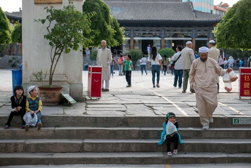 XINING, QINGHAI PROVINCE, CHINA - 2016/07/01: Children of local Muslim sit on the steps in Dongguan Great Mosque.   Dongguan Great Mosque, one of the four largest mosques and the highest institute of Islam in Northwest China.  About 7000 people attend prayer activities every day, nearly 20,000 on Djumah and 200,000 on Islamic festivals such as Eid. (Photo by Zhang Peng/LightRocket via Getty Images)