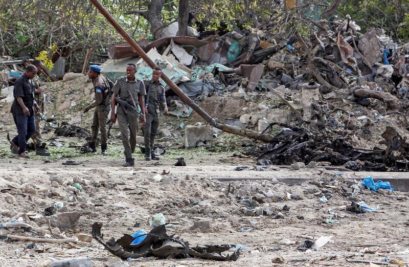 Somali soldiers attend the scene where a suicide car bomber detonated near the gates of the motor vehicle imports duty authority headquarters near the port in Mogadishu, Somalia. AP Photo