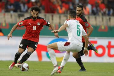 Egypt's Mohamed Salah, left, is challenged by Morocco's Nayef Aguerd, right, during the African Cup of Nations 2022 quarter-final soccer match between Egypt and Morocco at the Ahmadou Ahidjo stadium in Yaounde, Cameroon, Sunday, Jan.  30, 2022.  (AP Photo / Sunday Alamba)