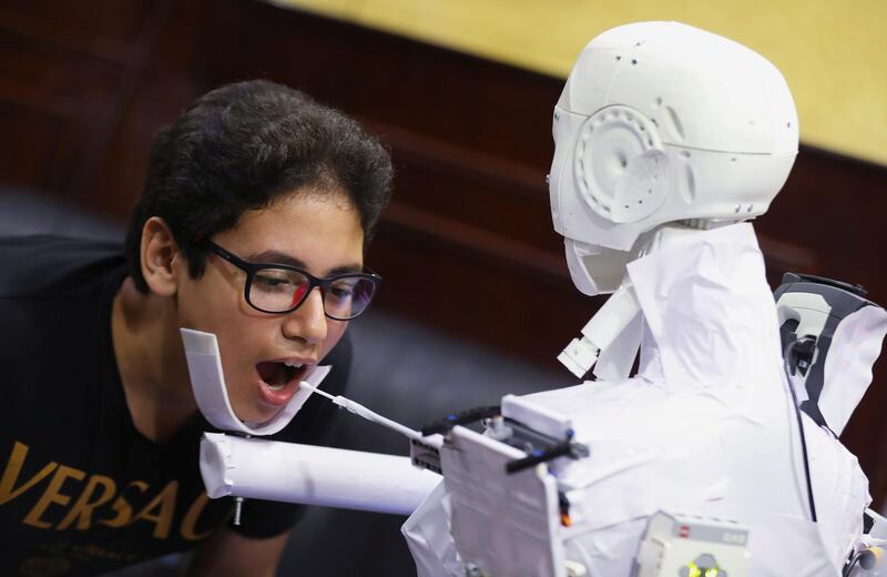 The remote-controlled robot that has been built by the Egyptian mechanical engineer, Mahmoud El komy, 26, tests a boy for the coronavirus by running PCR tests, limiting exposure to suspected cases, in Cairo, Egypt. Reuters