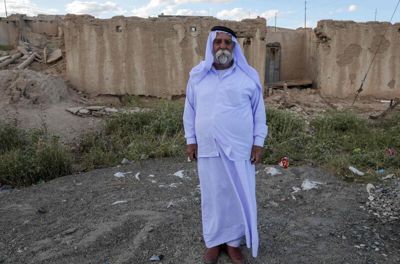 An Iraqi Yazidi man stands in front of a building destroyed during the 2014 attack by ISIS fighters in the village of Solagh in the Sinjar region of northern Iraq. AFP