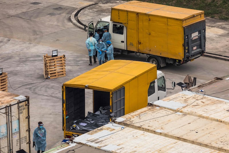Workers prepare to move dead bodies from a truck into a refrigerated container at the Fu Shan Public Mortuary, Hong Kong. Photo: AFP