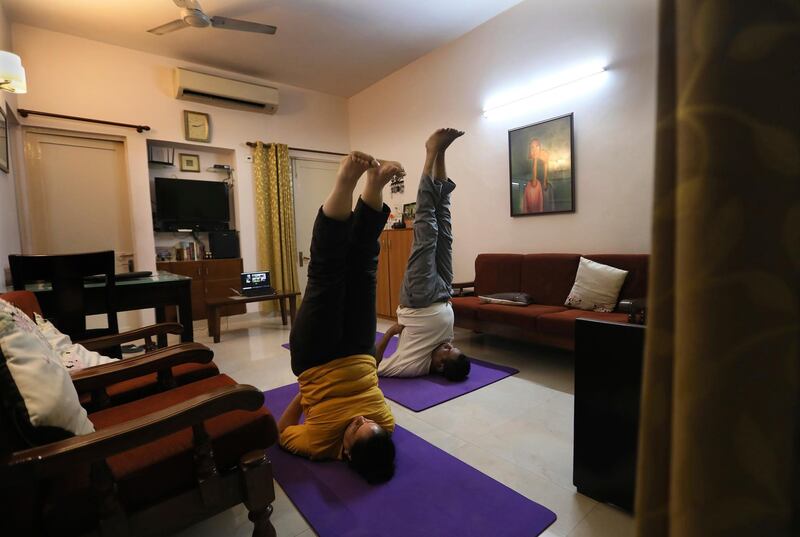 A couple practice yoga at their home through an online class in New Delhi, India. AP Photo
