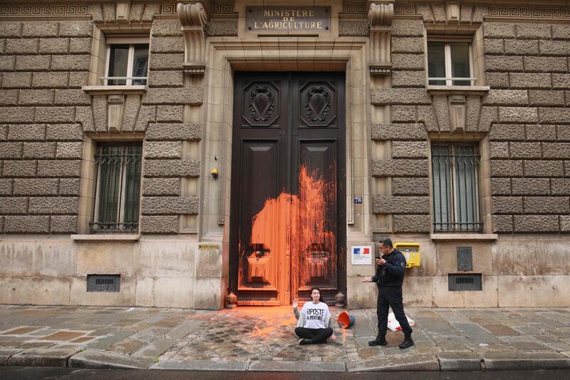 French police at the doorway of the Ministry of Agriculture after an activist of the environmental group 'Riposte Alimentaire' (Food Retaliation) threw a bucket of orange paint to protest for food sustainability in Paris. AFP