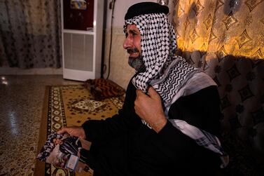 Jasb Hattab Aboud, father of the kidnapped protester Ali Jasb, cries as he holds his son's picture in his home in the town of Amara, Iraq. AP