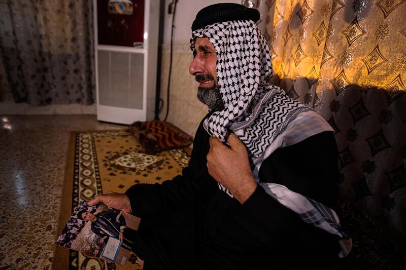 FILE - In this July 29, 2020 file photo, Jasb Hattab Aboud, father of the kidnapped protester Ali Jasb, cries as he holds his son's picture in his home un the town of Amara,Iraq.   Aboud was shot to death Wednesday, March 10, 2021, a human rights monitor and security officials said. Jasb Hattab Aboud died of a gunshot wound to the head at 6 p.m. in the southern city of Amara, said Ali al-Bayati, a spokesman for the semi-official Independent Human Rights Commission and a security official. (AP Photo/Nabil al-Jurani)