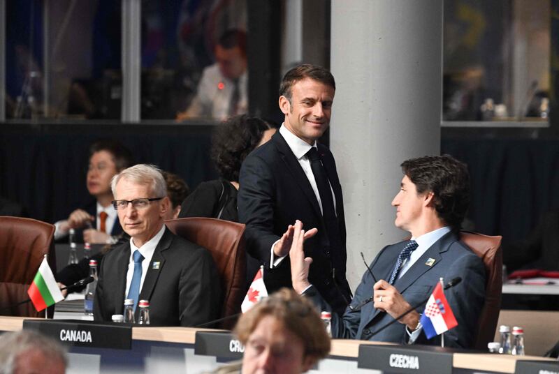 Mr Macron greets Canada's Prime Minister Justin Trudeau. AFP